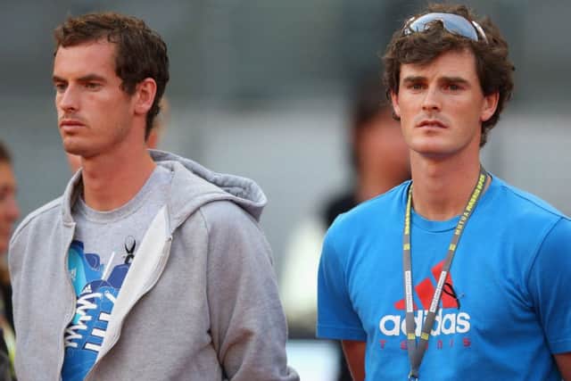 Wimbledon champion Andy Murray, left, and brother Jamie during a minutes silence at the Madrid Open last night. Picture: Getty