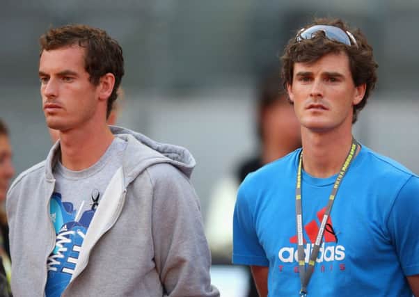 Wimbledon champion Andy Murray, left, and brother Jamie during a minutes silence at the Madrid Open last night. Picture: Getty