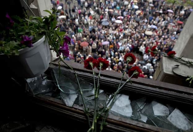 Flowers were left at the burnedout building in Odessa as people gathered to remember the victims of the fire. Picture: AP