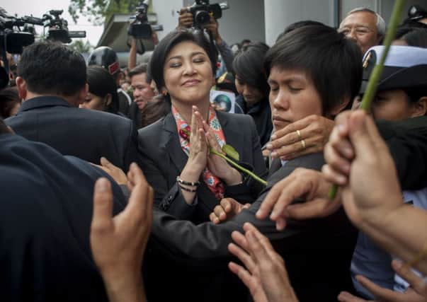 Yingluck Shinawatra is mobbed by supporters outside the defence secretarys office. Picture: Getty
