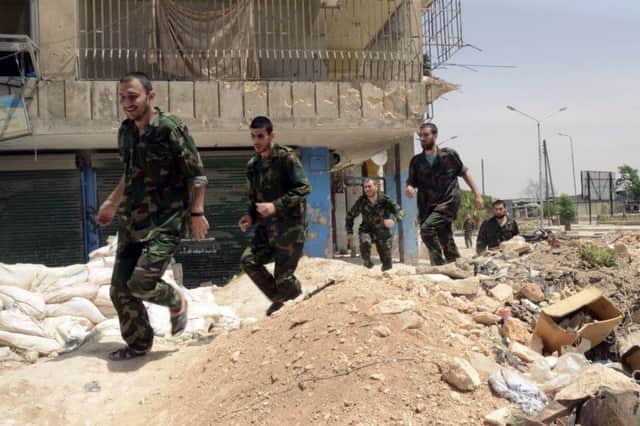 Troops loyal to the government run through Aleppo after their release by rebels. Picture: Reuters