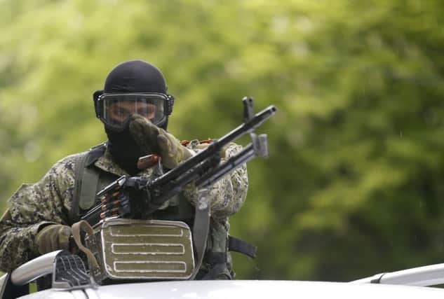 A pro-Russia gunman patrols Slovyansk in Ukraine yesterday as tensions remain high. Picture: AP