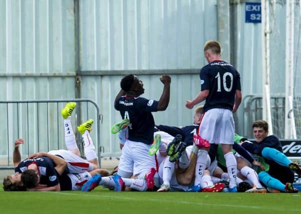 Falkirk players dive on top of Blair Alston after he scored the winning goal against Queen of the South in extra-time. Picture: SNS Group