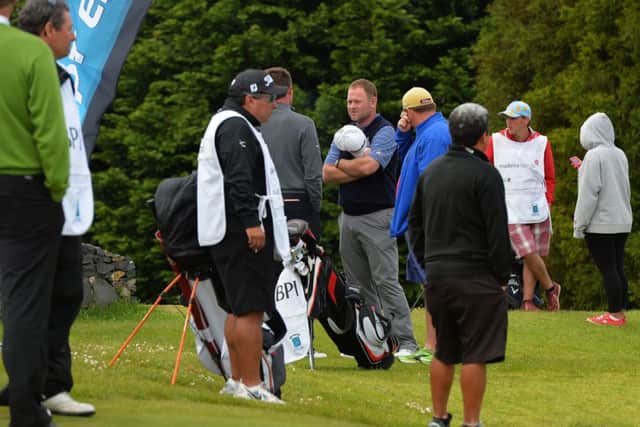 Scot Alastair Forsyth, centre with white hat, talks to golfers after his caddie Iain McGregor died on the 9th fairway. Picture: Getty