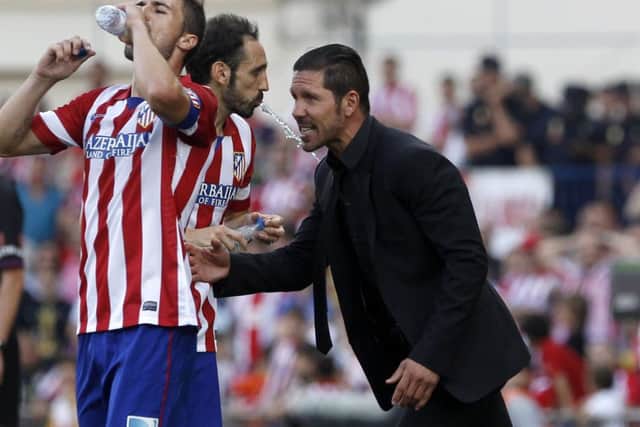 Atletico Madrids Argentinian coach Diego Simeone talks to his midfielder Juanfran and captain Gabi. Picture: AFP/Getty