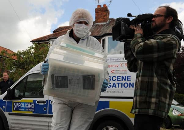 A forensic officer moves evidence from a house in York. Picture: PA