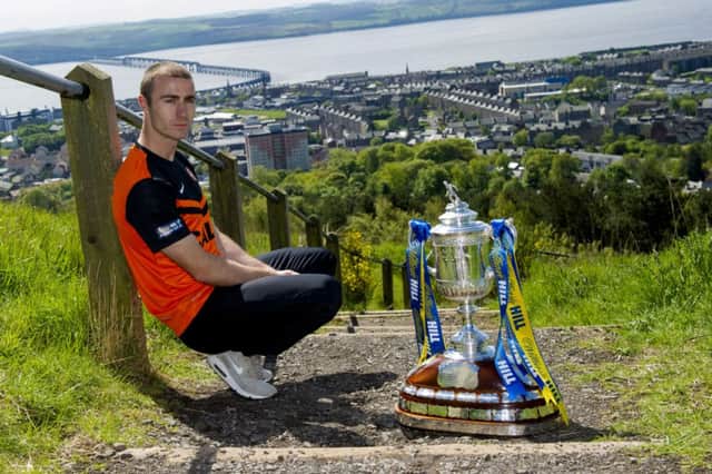 Sean Dillon sits with the Scottish Cup at The Law, with Dundee stretching out below. Picture: Craig Foy