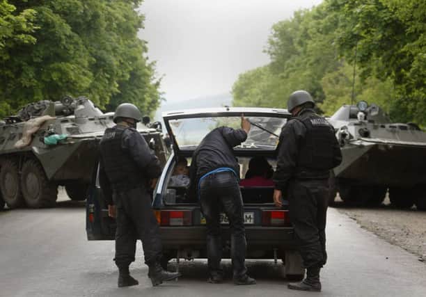 Interior ministry officers check a car at a roadblock in eastern Ukraine. Picture: Reuters