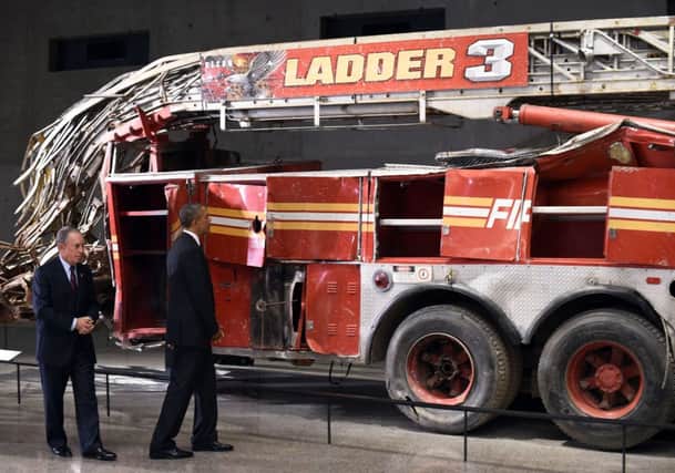 Barack Obama and former New York mayor Michael Bloomberg view a damaged fire engine that was on duty on 9/11. Picture: Getty