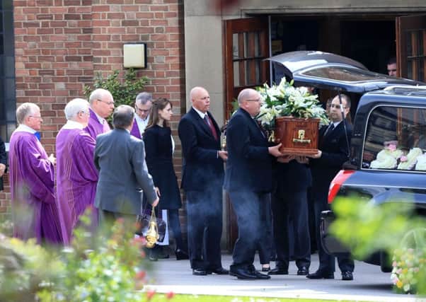 Ann Maguires coffin is carried out of church as members of the clergy watch on.  Picture: PA