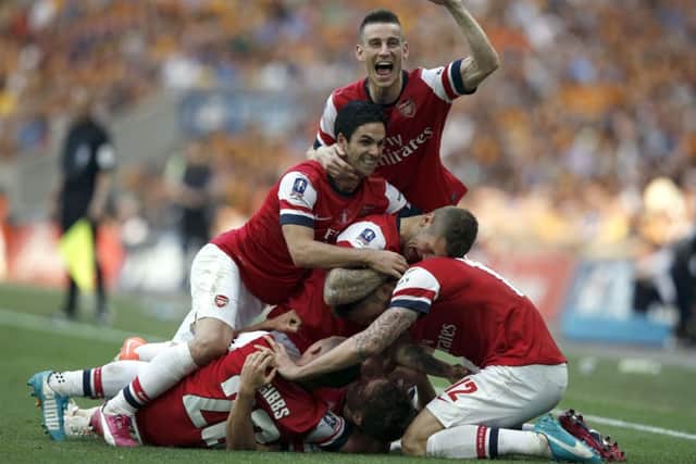 Arsenal players mob Aaron Ramsey after he scored the winning goal. Picture: Getty
