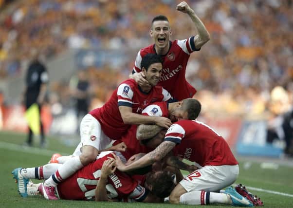 Arsenal players mob Aaron Ramsey after he scored the winning goal. Picture: Getty