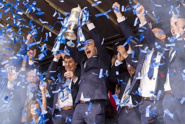St Johnstone captain Dave Mackay hoists the Scottish Cup aloft amid a blizzard of tickertape. Picture: SNS