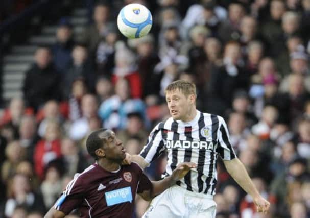 David van Zanten heads the ball clear despite the close attention of Hearts forward Michael Ngoo. Picture: Phil Wilkinson
