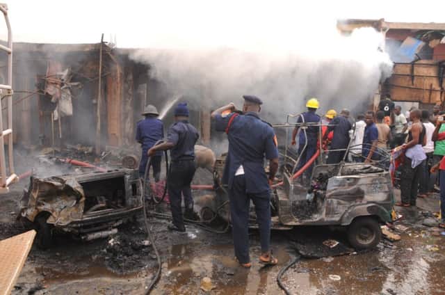 Firefighters douse the debris from the car bomb attacks in the central city of Jos. Picture: Getty