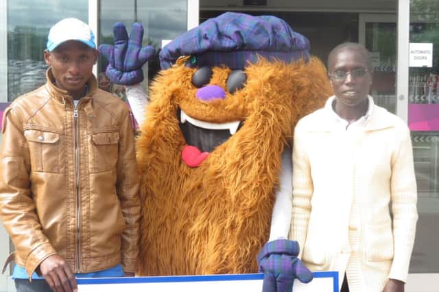 David Toniok and his fellow Kenyan Risper Kimaiyo are greeted by mascot Hairy Haggis. Picture: Contributed