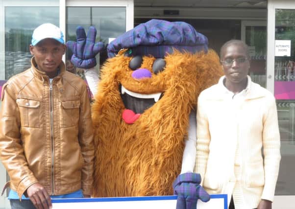 David Toniok and his fellow Kenyan Risper Kimaiyo are greeted by mascot Hairy Haggis. Picture: Contributed