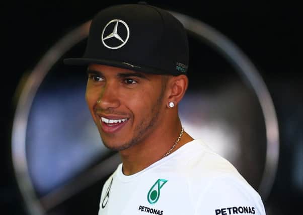 Lewis Hamilton shares a joke in the Mercedes team garage yesterday. Picture: Getty