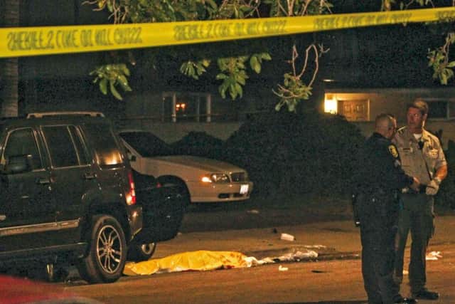 Police stand near a dead body at the scene of a drive-by shooting in Isla Vista, California. Picture: Reuters