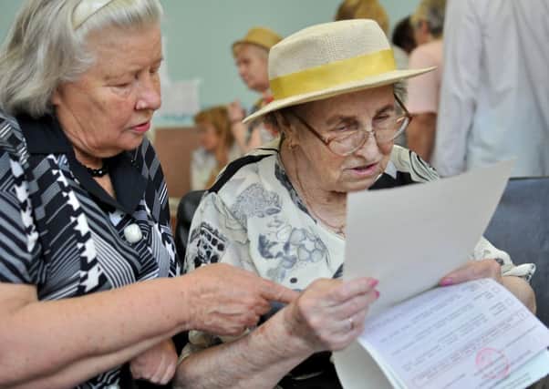 Two elderly voters study the form before casting their votes in the Ukrainian presidential elections. Picture: Demotix
