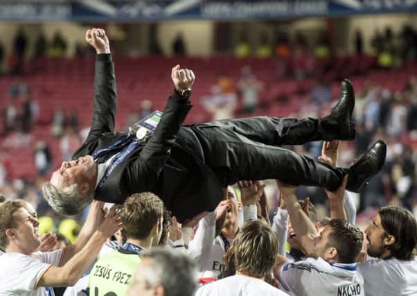 Jubilant Real Madrid coach Carlo Ancelotti is hoisted into the air by his elated stars.  Picture: SNS