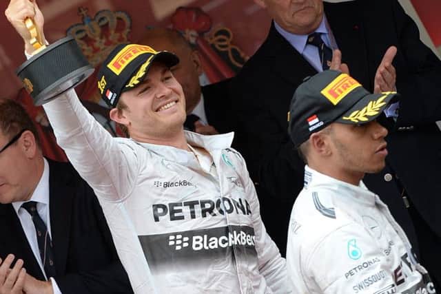 Nico Rosberg celebrates first place as Lewis Hamilton leaves the podium. Picture: Getty