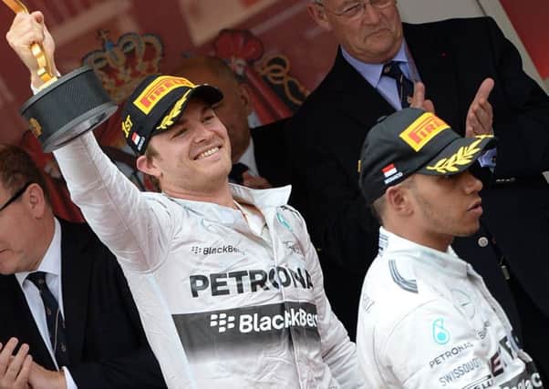 Nico Rosberg celebrates first place as Lewis Hamilton leaves the podium. Picture: Getty
