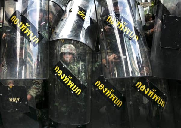 Thai military stand behind their riot shields during an anticoup demonstration in Bangkok. Picture: Getty