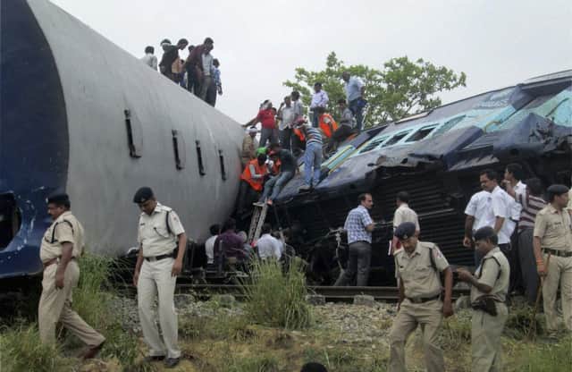 Officials and rescuers gather around the wreckage after the two trains collided near a station in Uttar Pradesh state. Picture: AP
