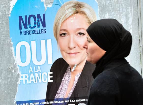A women walks by a campaign poster of French far-right Front National (FN) party president Marine Le Pen. Picture: AFP/Getty
