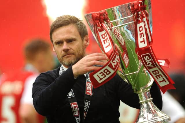 Fleetwood manager Graham Alexander shows off the League Two play-off trophy. Picture: PA