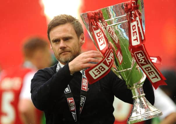 Fleetwood manager Graham Alexander shows off the League Two play-off trophy. Picture: PA
