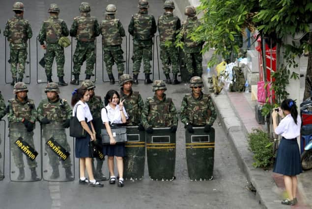 A group of schoolgirls have a photograph taken with troops stationed to prevent anticoup protests in Bangkok. Picture: AP