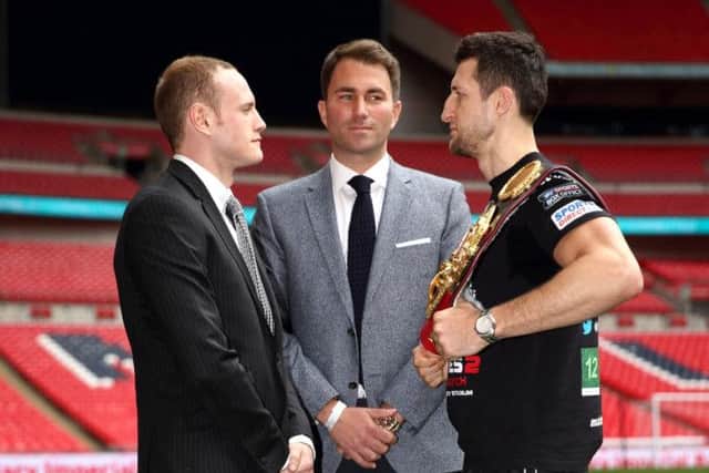 Promoter Eddie Hearn stands inbetween champion Carl Froch, right, and challenger George Groves. Picture: Getty