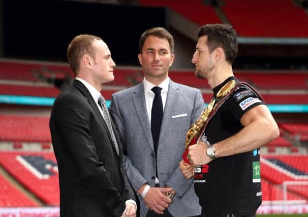 Promoter Eddie Hearn stands inbetween champion Carl Froch, right, and challenger George Groves. Picture: Getty