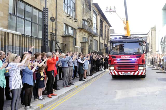 Staff and students line the road to perform a guard of honour for fire crews. Picture: John Devlin