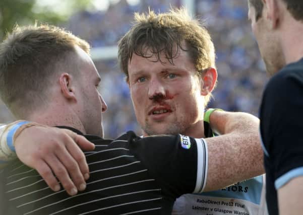 Bloodied in battle: Peter Horne is consoled at full-time. Picture: SNS