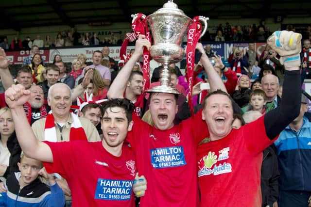 Hurlford Uniteds delighted players begin the celebrations after winning the Barr Scottish Junior Cup at Rugby Park yesterday. Picture: SNS
