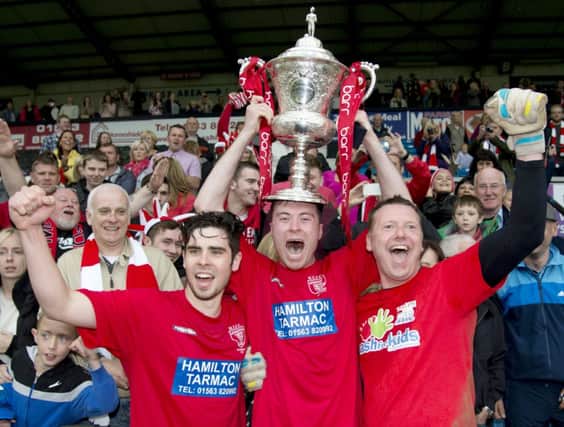 Hurlford Uniteds delighted players begin the celebrations after winning the Barr Scottish Junior Cup at Rugby Park yesterday. Picture: SNS