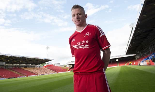 Jonny Hayes shows off the new home kit at Pittodrie. Picture: SNS