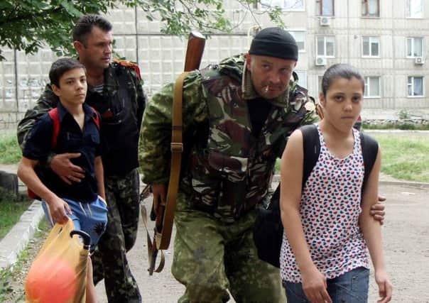 Separatist fighters escort children away from the fighting in Luhansk. Picture: Getty