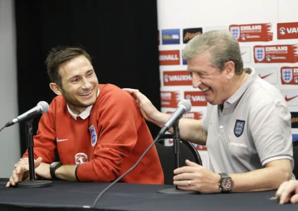 Frank Lampard jokes with manager Roy Hodgson at a press conference. Picture: AP