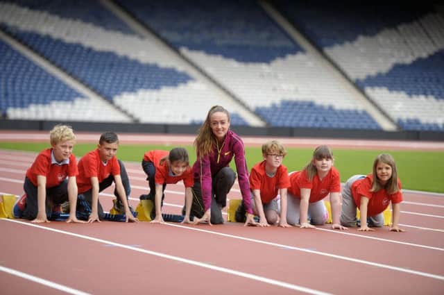Eilish McColgan is joined by schoolchildren to unveil the Commonwealth Games athletics track. Picture: John Devlin
