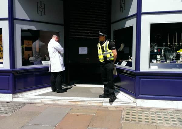A police officer stands guard outside Hamilton and Inches on George Street after a robbery. Picture: Contributed