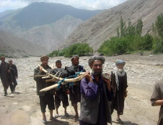 Villagers carry away the body of one the many victims who died in the flood in northern Afghanistan. Picture: AFP/Getty
