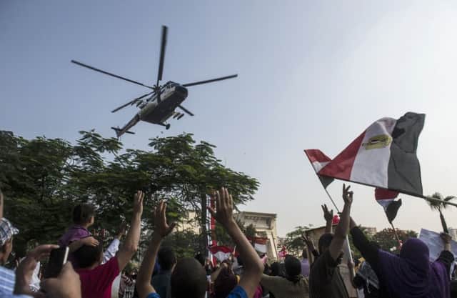 A police helicopter hovers over the crowds gathered outside Cairos high court. Picture: Getty