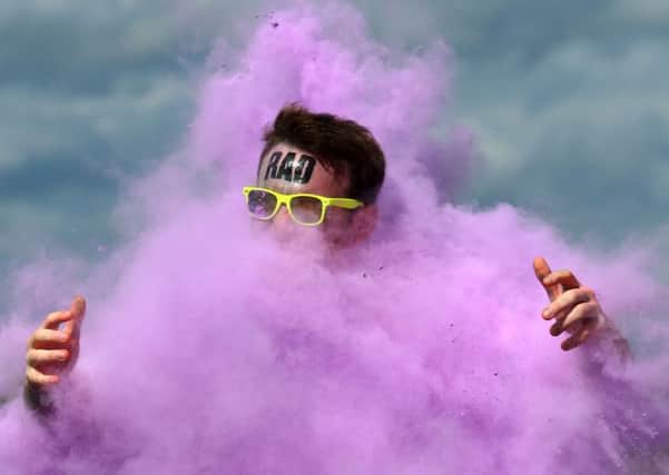 A runner is engulfed in a clowd of colour. Picture: PA