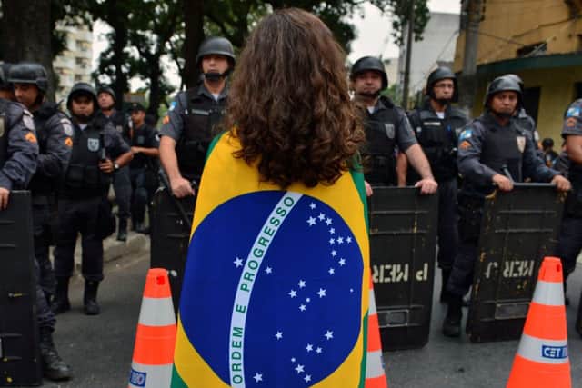 Anti riot police officers block protesters in a street close to the Maracana stadium of  Rio de Janeiro. Picture: Getty