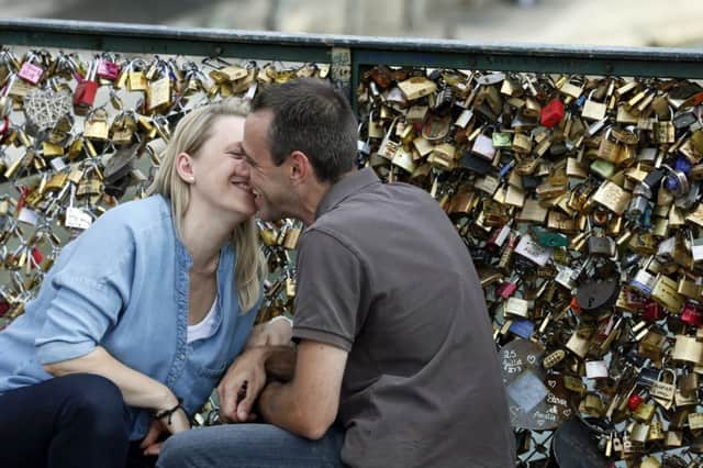 Locked in an embrace: canoodling at the padlock-festooned Pont des Arts. Picture: Getty