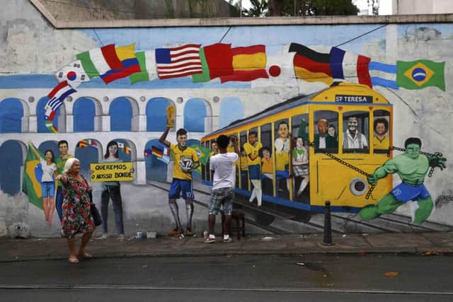 Graffiti of Brazils Hulk pulling a tram while fellow striker Neymar holds aloft the World Cup in Rio de Janeiro. Picture: Reuters